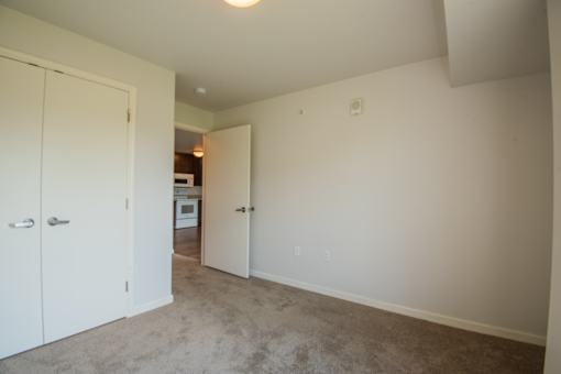 A white door is open to a kitchen.