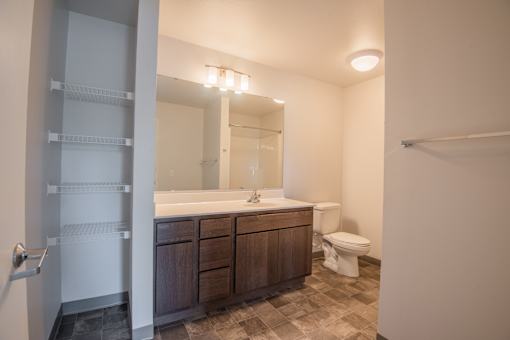 A bathroom with a toilet, sink, and mirror.