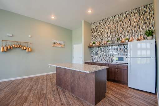 A kitchen with a white refrigerator and wooden floors.
