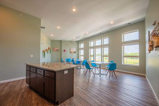 A kitchen with a table and chairs in front of a window.