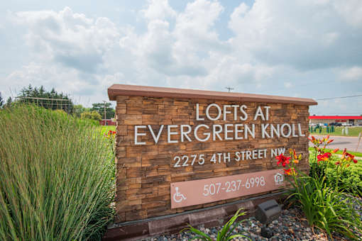 A sign for Lofts at Evergreen Knoll with a phone number on it.