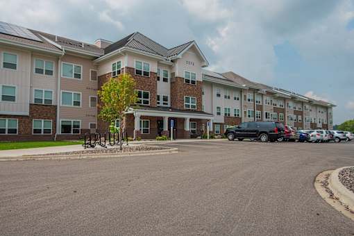 A large apartment complex with a parking lot in front.