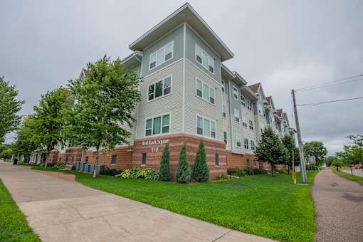 A large apartment building with a brick base and a grey top floor.