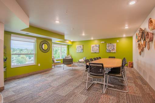 A room with a green wall and a table with chairs.