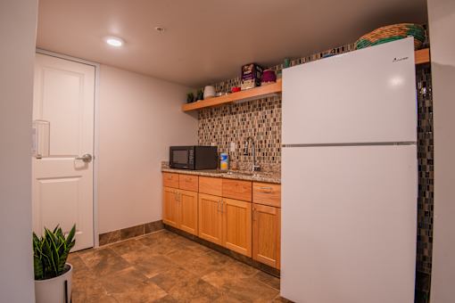 A kitchen with a white refrigerator and wooden cabinets.