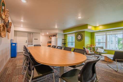 A conference room with a large table surrounded by chairs.