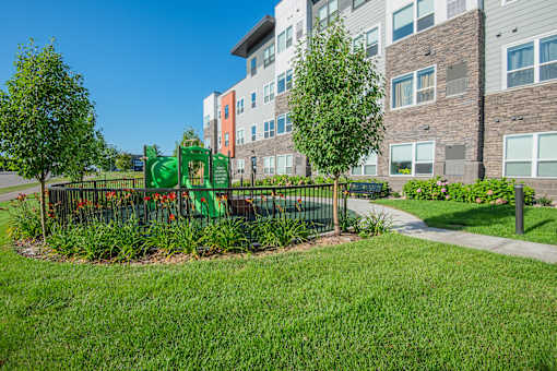 A green playground in front of a building.