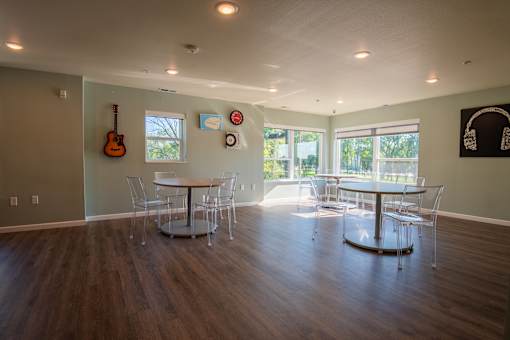 A room with a wooden floor and a guitar hanging on the wall.