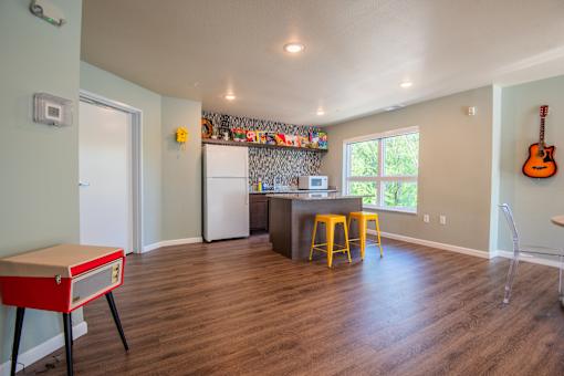 A kitchen with a white refrigerator and yellow stools.