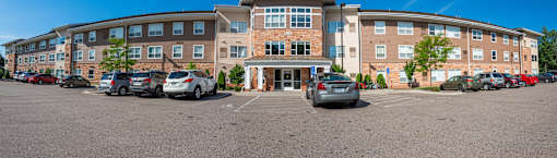 A large building with a parking lot in front of it.