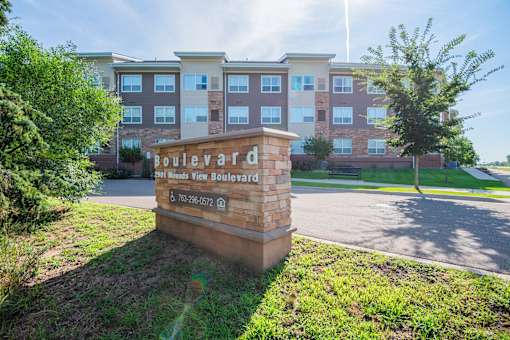 A sign for Boulevard Apartments stands in front of a building.