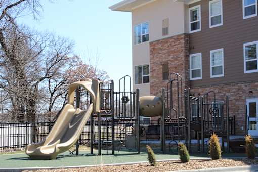 A playground with a slide and a climbing frame.