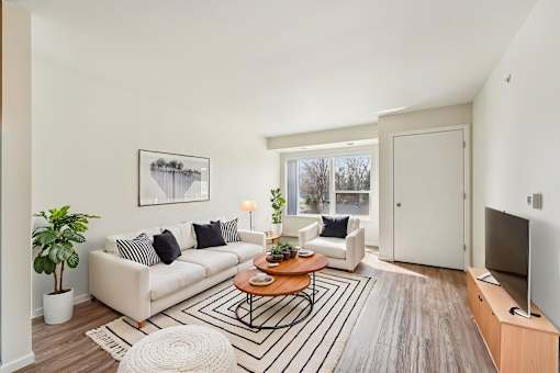A living room with a brown sofa, a white coffee table, and a flat screen TV.