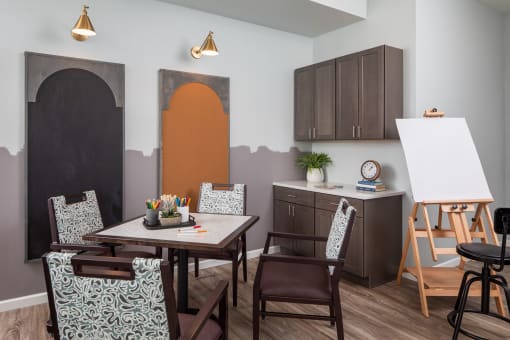 a dining room with a table and chairs and a kitchen with a chalkboard wall