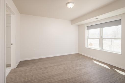 A room with a window and a wooden floor.