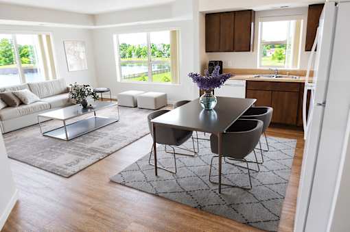 A modern dining room with a glass table and chairs.