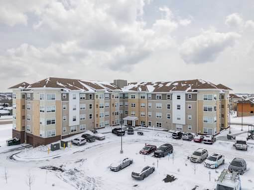 A large apartment complex with a parking lot full of cars.