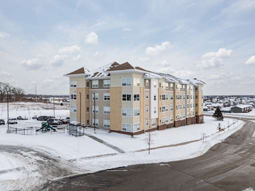 A large apartment complex with a playground in the snow.