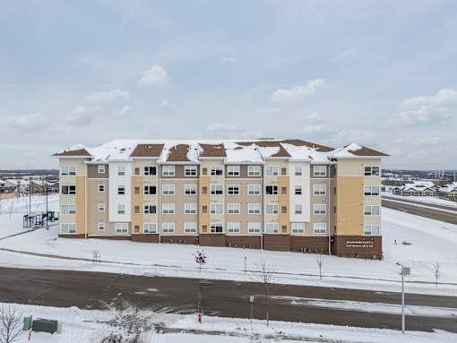 A large building with a brown and beige facade sits in the snow.
