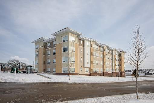 A large apartment building with a playground in the foreground.