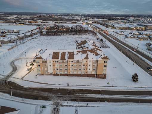 A large building sits in the middle of a snowy road.