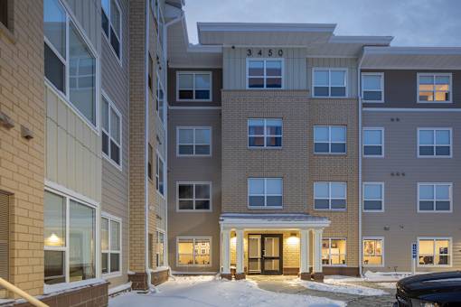 The image shows a multi-story residential building with the number 3450 on the top.