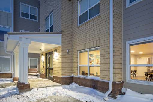 A building with a snowy ground in front.