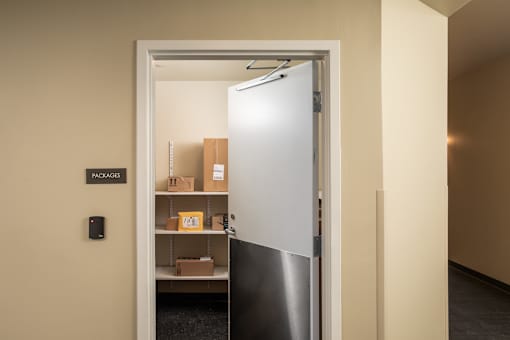 A doorway leads to a room with a shelf of boxes and a sign that says packages.