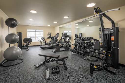 A well-equipped gym with a variety of exercise machines and weights.