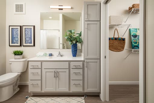 A bathroom with a white toilet, a white sink, and a white cabinet.