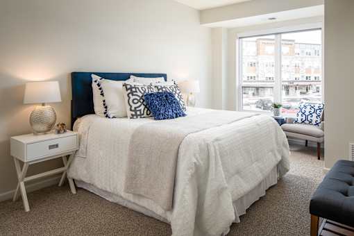 A bedroom with a large bed and a window overlooking a street.