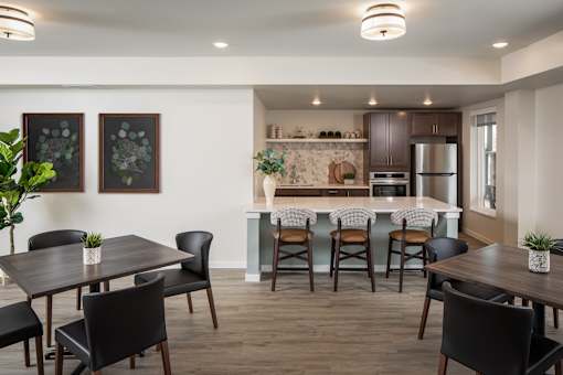 A modern kitchen with a dining table and chairs.