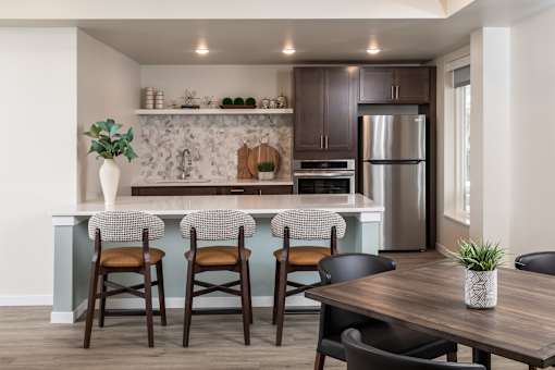 A kitchen with a bar area and a dining table.