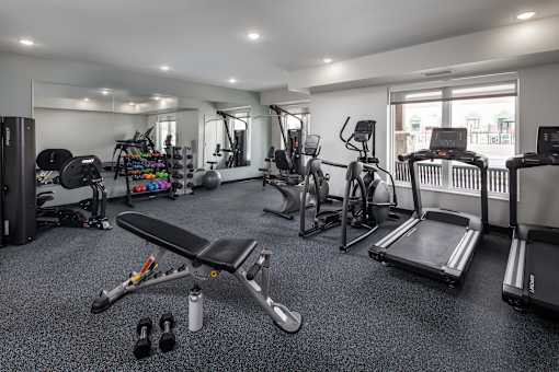 A well-equipped home gym with various exercise machines and equipment.