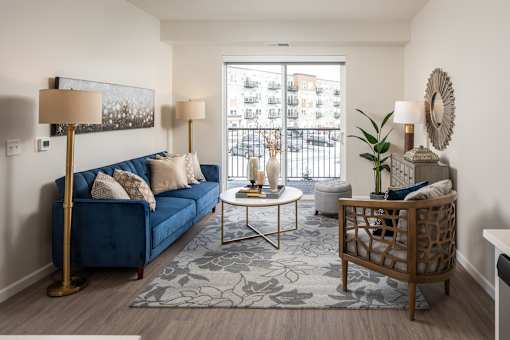 A living room with a blue couch, a coffee table, and a lamp.