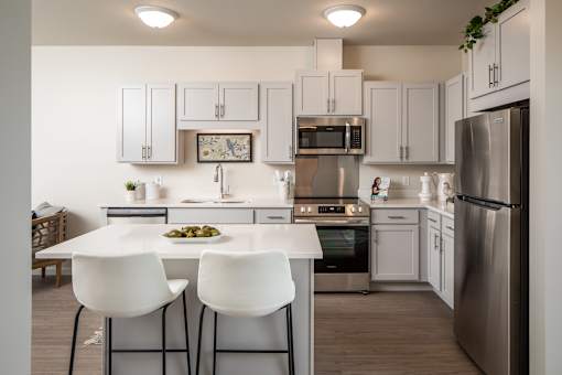 A modern kitchen with white cabinets and a center island.