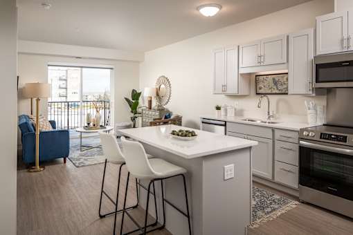 A kitchen with a white countertop and a blue sofa.