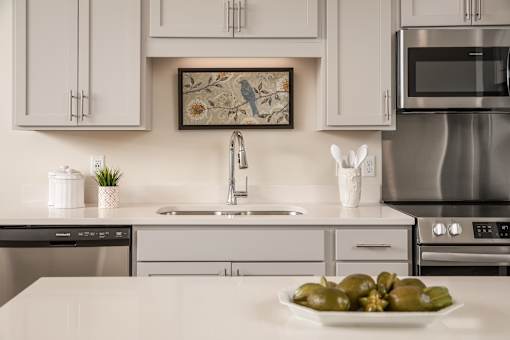 A modern kitchen with a stainless steel oven and a framed picture on the wall.