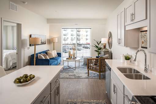 A kitchen with a blue sofa and a table with a plant on it.