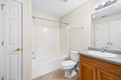 A white bathroom with a toilet, sink, and bathtub.