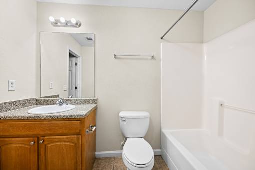 A white toilet sits next to a sink in a bathroom.