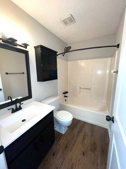 A bathroom with a white sink, toilet, and bathtub.