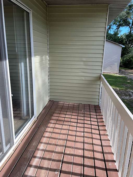 A patio with a tiled floor and a sliding glass door.