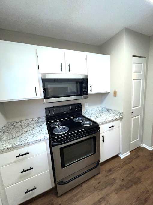 A kitchen with a stove top oven and microwave above it.