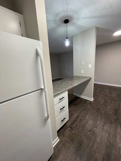 A white refrigerator with a drawer underneath it in a kitchen.