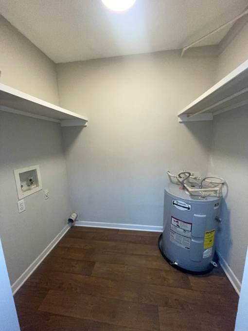 A room with a water heater on the floor.