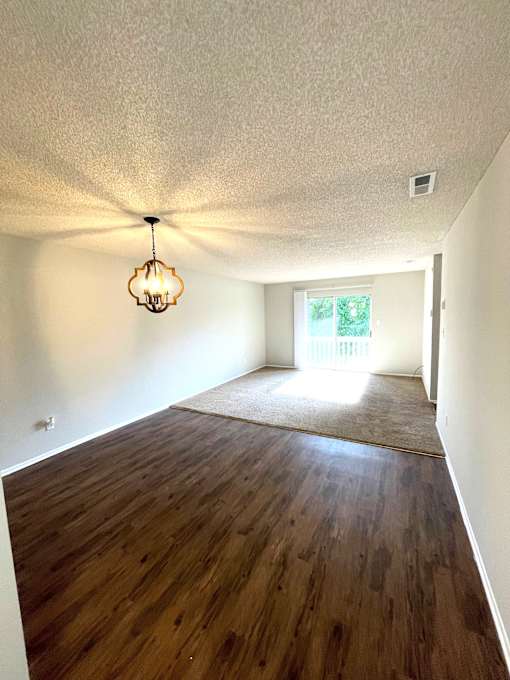A room with wooden floors and a hanging light fixture.