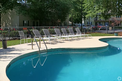 a pool with a bunch of lounge chairs around it