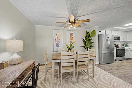 A dining room with a wooden table and chairs.