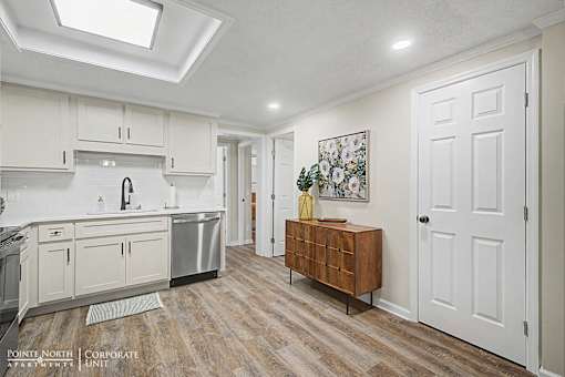 A kitchen with a wooden floor and white walls.